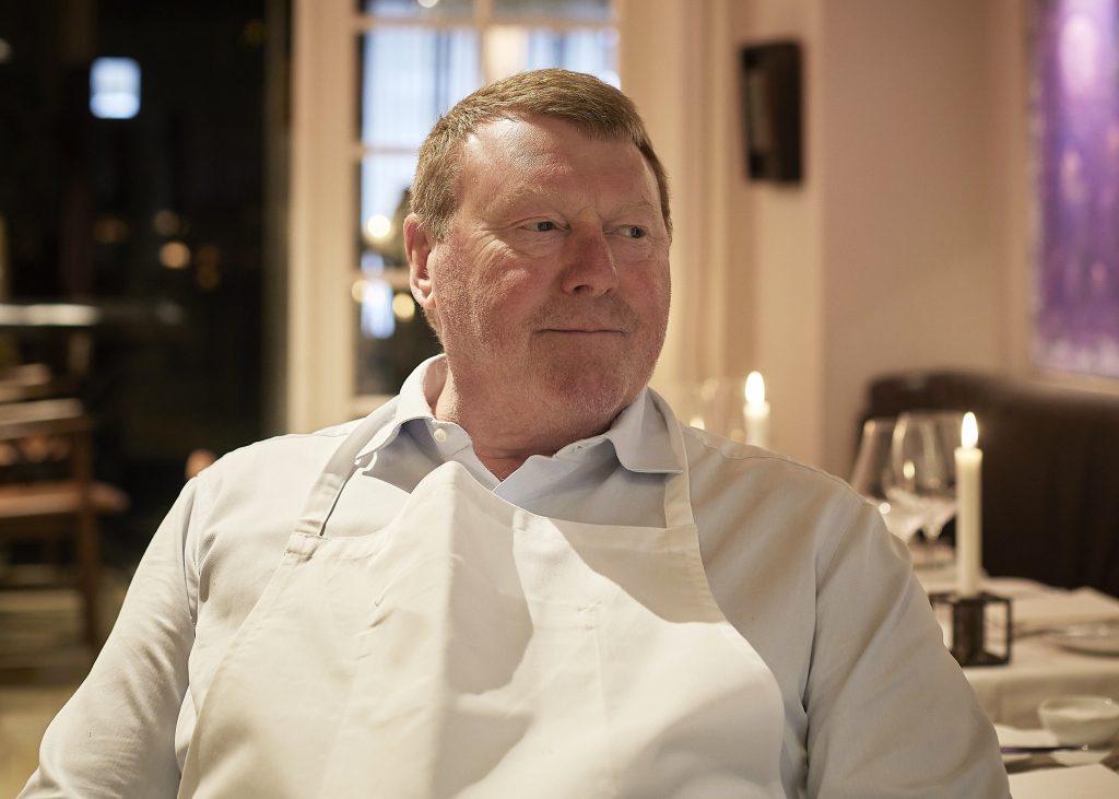 Claus Christensen – bedre kendt som Røde Claus. Han er kok, kunstelsker og kompromisløs bistroentusiast med et hjerte, der banker for det klassiske håndværk og de smage, vi aldrig glemmer.